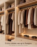 Kledingkast met kleding op hangers. Tekst: Extra ruimte om op te hangen. Ook handig voor kleding op hangers.