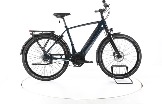 Zijaanzicht van een donkerblauwe Gazelle elektrische stadsfiets met zwarte accenten en bagagedrager.