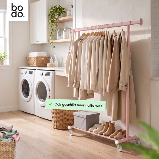 Roze kledingrek met beige kleding in een wasruimte naast twee wasmachines. Tekst: 'Ook geschikt voor natte was'.