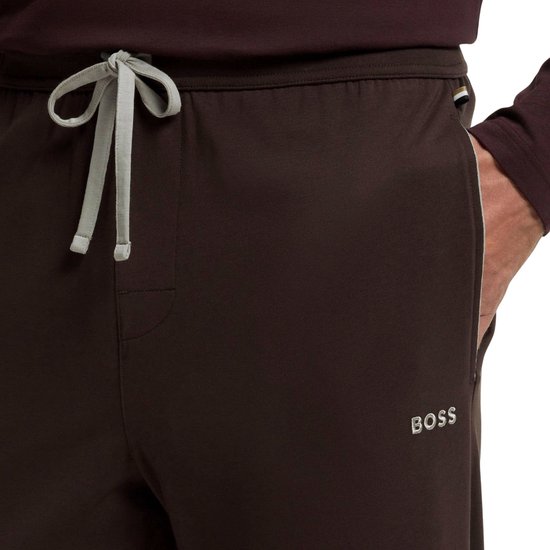 Detailopname van bruine BOSS-joggingbroek met lichtgrijs trekkoord en logo op de broekspijp.