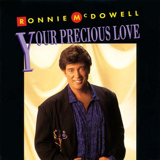 Ronnie McDowell, "Your Precious Love", zwart colbert, blauw paars shirt met print, lichte achtergrond.