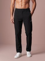 Model draagt een zwarte sportbroek in stretchstof met twee zakken met rits, het Sjeng Sports logo op de linkerheup.