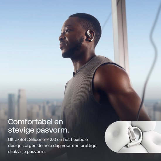 Man met witte Shokz OpenFit Pro oordopjes, die comfortabel en stevig zitten.