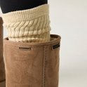Close-up van bruine suède laars met beige beenwarmers, 'WATERPROOF' en 'REGATTA' logo.