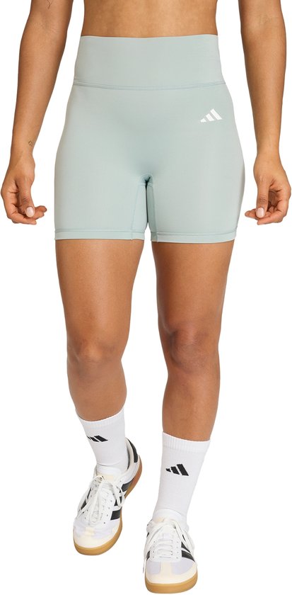Lichtgroene tight fit short voor dames met witte Adidas logo op linker bovenbeen.