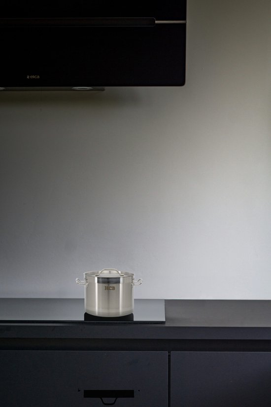 Roestvrijstalen HcB kookpan op een inductiekookplaat in een minimalistische keuken.