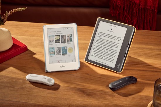 Een witte Kobo afstandsbediening, een gele en een witte eReader op een houten tafel.