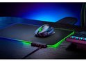 Zwarte Razer gaming muis met groene details, staand op een zwart gamingmuismat met gloeiende groene en blauwe randen, naast een toetsenbord.