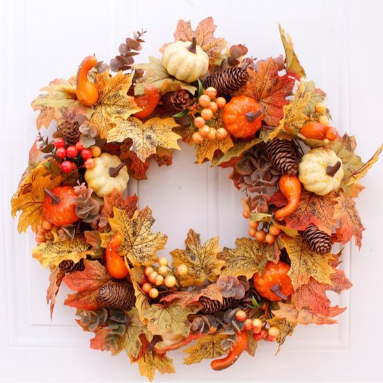 Herfstkrans met pompoenen, bessen, dennenappels en bladeren.