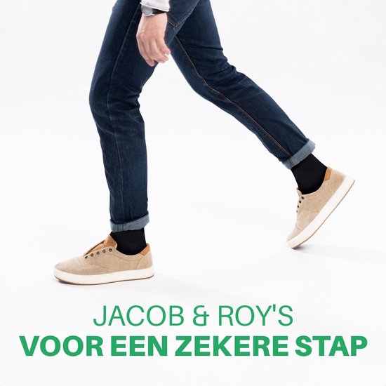 Man in spijkerbroek en sneakers draagt zwarte sokken van Jacob & Roy's.