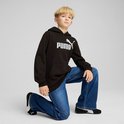 Jongen knielt in een zwarte PUMA hoodie en spijkerbroek, met logo op de borst.