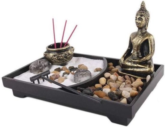 Zen tuin met Boeddhabeeld, wierookhouders met rode wierookstokjes, stenen en een harkje.