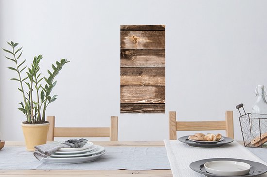 Planches verticales en bois brun avec des nœuds et des zones usées, suspendues au-dessus d'une table à manger.