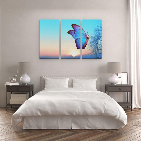 Drieluik schilderij met een blauwe vlinder op een paardenbloem tegen een zonsondergang achtergrond.