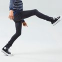 Jongens model in een skinny jeans en een gestreepte longsleeve.