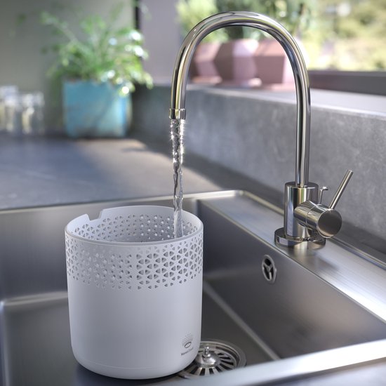 Réservoir blanc d'un humidificateur d'air rempli d'eau dans un évier.