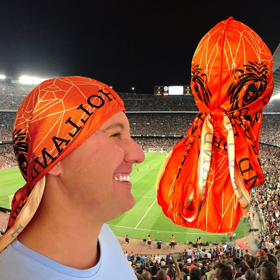 Oranje bandana met tekst HOLLAND en leeuwenkop, op de achtergrond een voetbalstadion.