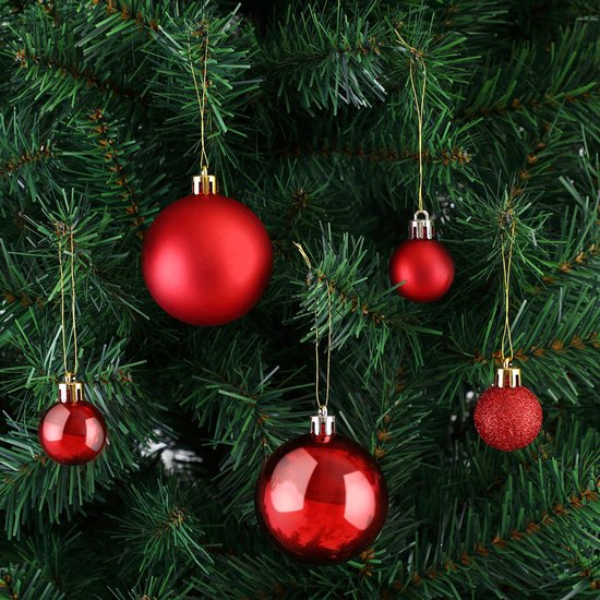 Vijf rode kerstballen van verschillende maten hangen aan een kerstboom.