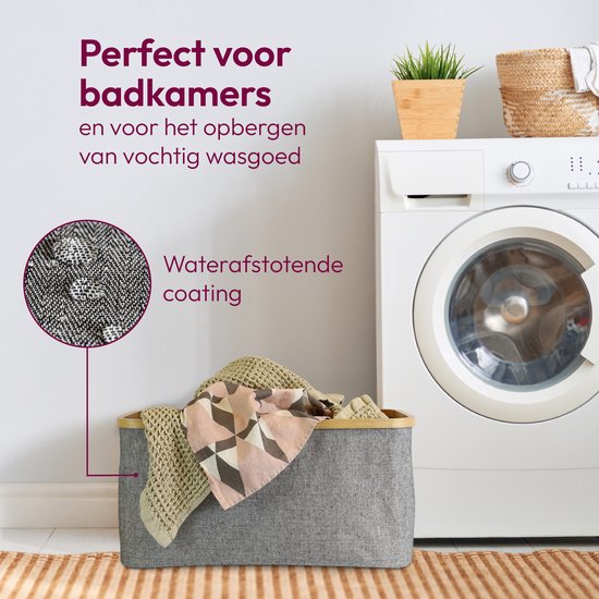 Grijze wasmand met bamboe rand gevuld met handdoeken, waterafstotende coating.