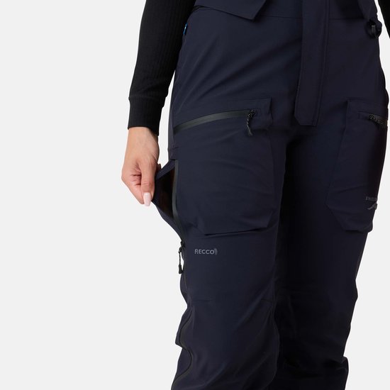 Dichtbij de linkerbroekspijp van een donkerblauwe skibroek, model opent een ritszak.