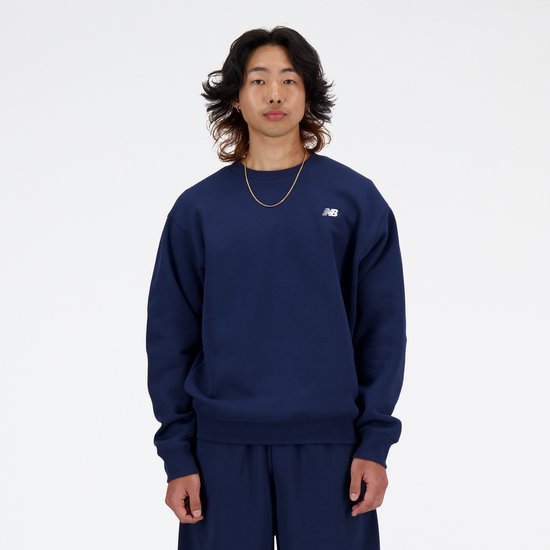 Donkerblauwe New Balance trui met wit logo op borst gedragen door een man.