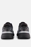 Achterkant van zwarte Skechers sneakers met zilverkleurige accenten op de hiel.