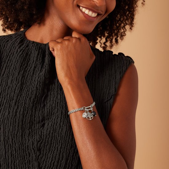 Vrouw met zilverkleurige schakelarmband met levensboom, rechthoekige steen en blauwe steen