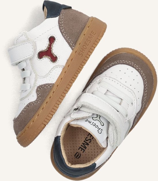 Wit leren babyschoenen met bruine en donkerblauwe accenten, klittenbandsluiting en veters.