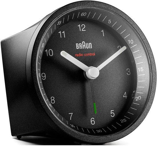 Zwarte Braun wekker met analoge wijzerplaat, witte wijzers en groene secondewijzer, van opzij gezien.
