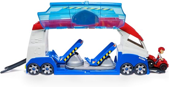 Een jongen drukt op een knop op de PAW Patrol Patroller, een groot blauw, wit en rood voertuig met transparante deuren.