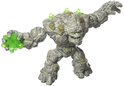 Grijs steenmonster met groene kristallen en mos, met kristallen in de linkerhand.