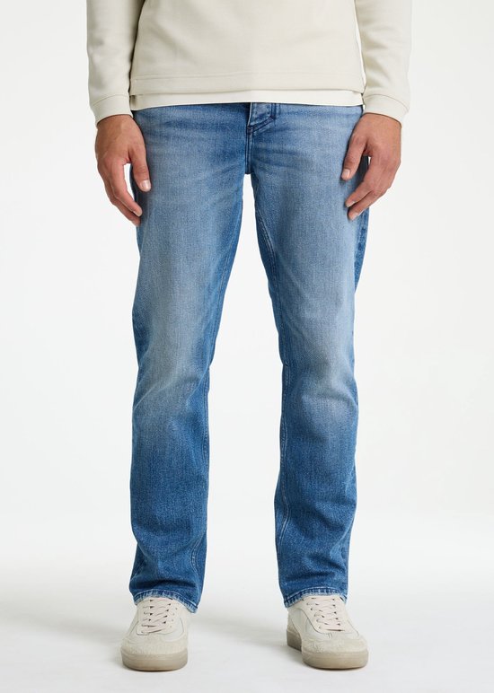 Man draagt een lichtblauwe denim jeans met een relaxte fit. De jeans heeft een geleidelijke wassing van lichtblauw naar donkerblauw.