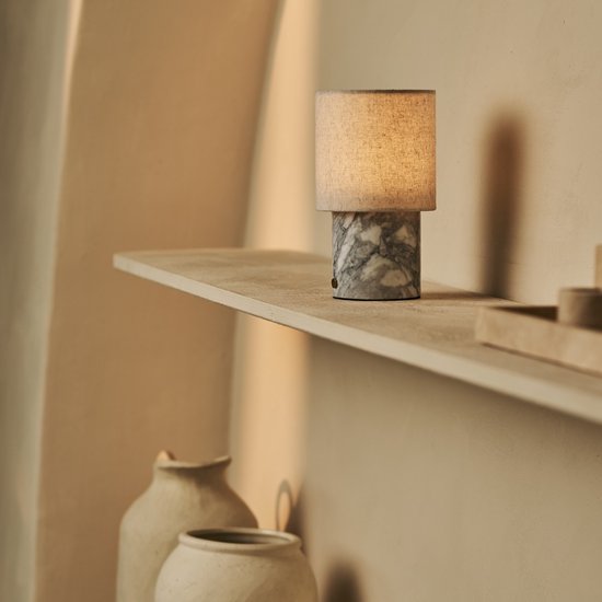 Tafellamp met een marmeren voet in Bianco Statuarietto en een beige linnen kap.