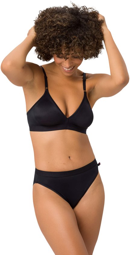 Model met krullend haar dat een zwarte beha en slip draagt, met handen in het haar.
