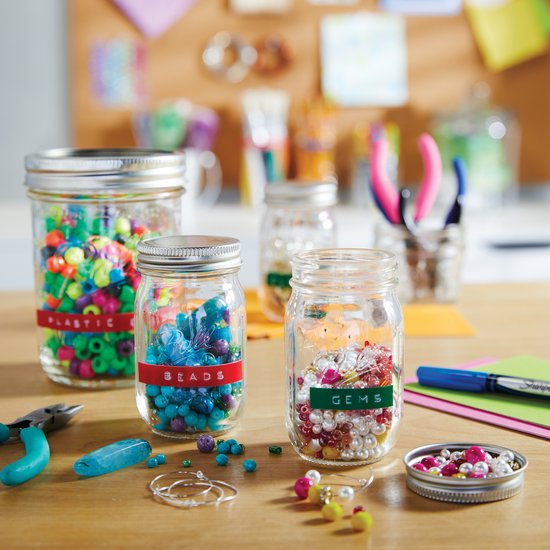 Potten met kralen met gekleurde etiketten: 'PLASTIC', 'BEADS' en 'GEMS'.