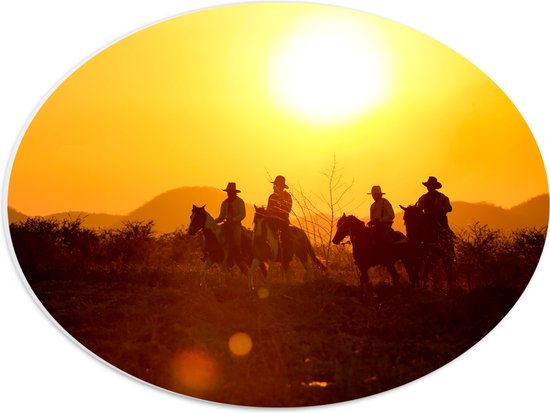 PVC Schuimplaat Ovaal - Groepje Cowboys op Paarden Rijdend door Landschap bij de Ondergaande Zon - 40x30 cm Foto op Ovaal (Met Ophangsysteem)