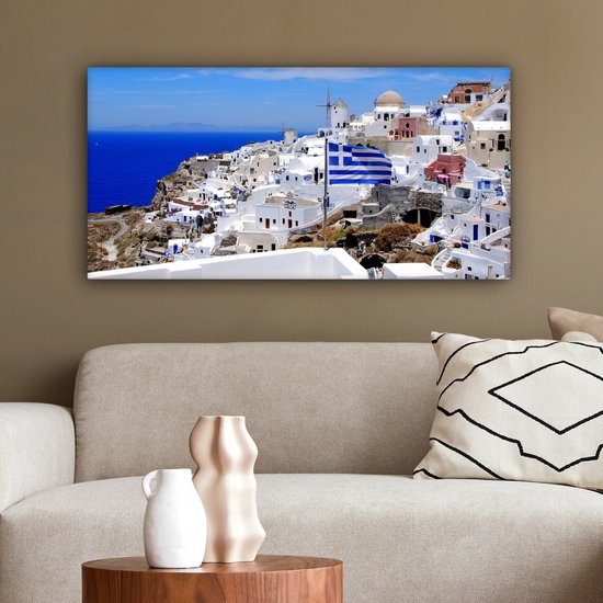 Canvas schilderij 80x40 cm - Wanddecoratie Vlag van Griekenland tussen de witte huisjes - Muurdecoratie woonkamer - Slaapkamer decoratie - Kamer accessoires - Schilderijen op canvas