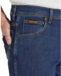 Close-up van de zak van een donkerblauwe Wrangler-spijkerbroek met koperen studs en leren detail.