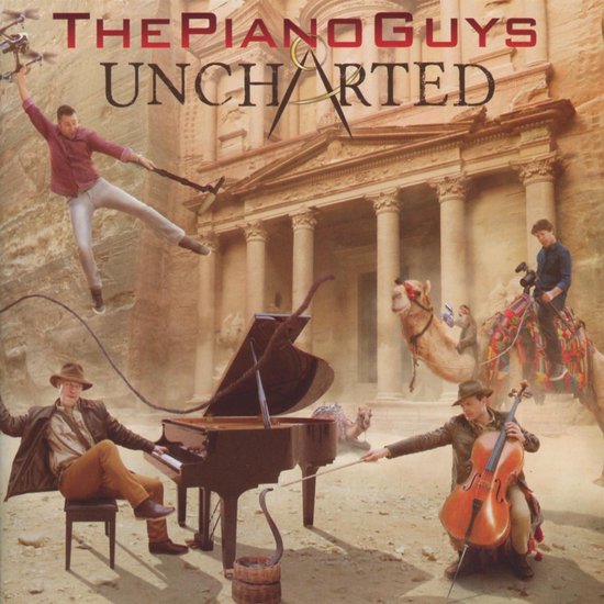 The Piano Guys 'Uncharted' albumhoes met een vleugelpiano, cello, kameel en mannen bij de ruïnes van Petra.