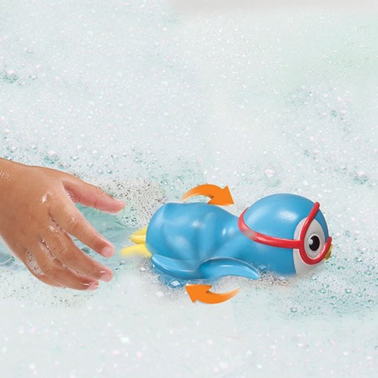 Blauwe opwindbare pinguïn met rode duikbril zwemt door bubbelbad, hand van kind nadert.