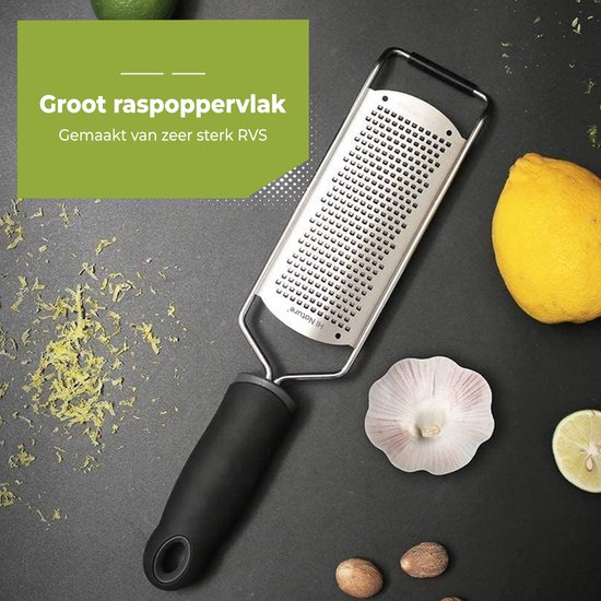 Râpe en acier inoxydable avec grande surface de râpage et manche noir, avec citron, noix de muscade et citron vert.