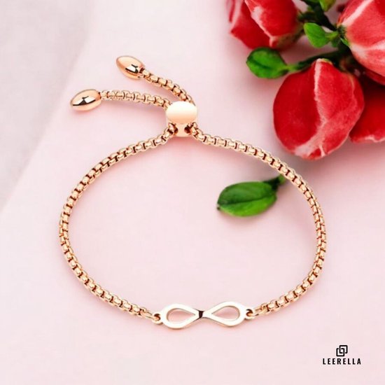 Rosé gouden infinity armband met verstelbare ketting, zittend op een roze ondergrond.