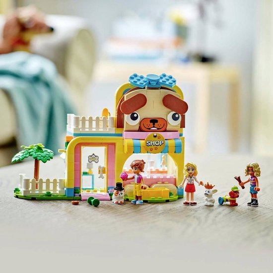 Fille avec un set LEGO Friends de boutique d'accessoires pour animaux, aux couleurs rose, jaune et bleu.