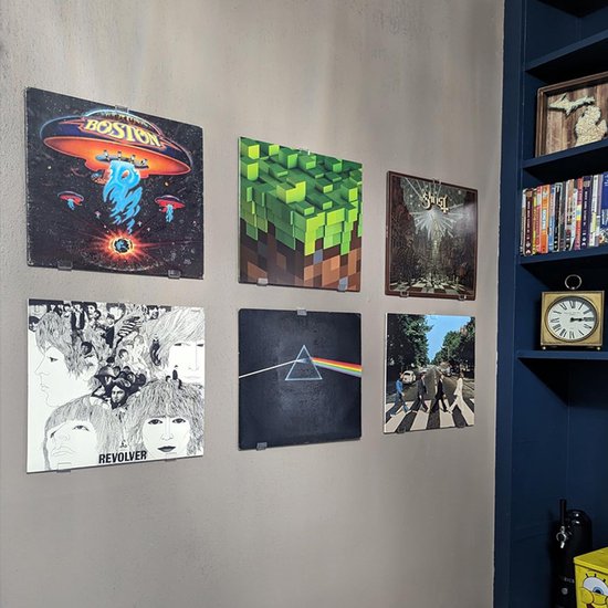 Wand met zes vinylplaten, waaronder 'Revolver' en 'The Dark Side of the Moon'.