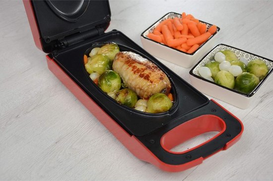 Rode grill met open deksel, met een stuk vlees, spruitjes en aardappelen.