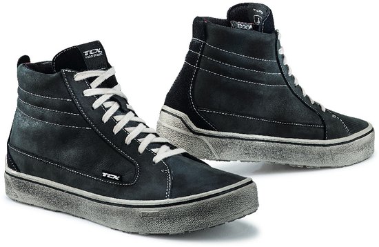 Paar verweerde zwarte hoge sneakers met witte veters en rubberen zolen met grijze rand.