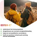 Twee vrouwen in buitenkleding lopen met tassen en thermosbeker. Ester-C 1000 mg ondersteunt het immuunsysteem.