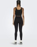 Zicht op de achterkant van een model met zwarte crop top en zwarte, nauwsluitende sportlegging met hoge taille.