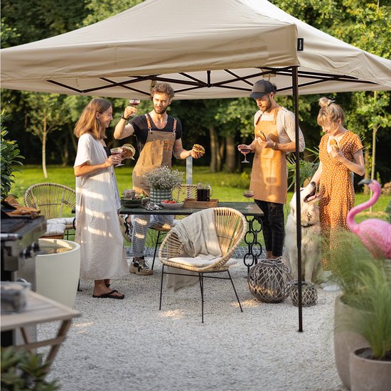 Een groep vrienden geniet van een barbecue onder een beige LifeGoods partytent in de tuin.