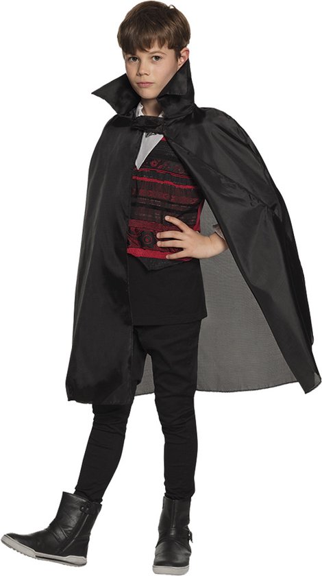 Jongen in vampierkostuum met zwarte cape, zwart shirt, rood vest met patroon en zwarte broek.